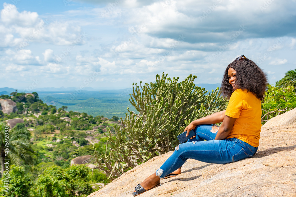 young african woman sitting on a rock