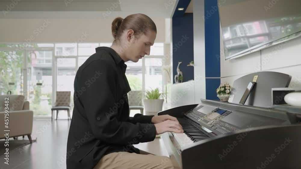 man happily plays the piano in the lobby of the hotel.
man happily plays the piano in the lobby of the hotel.