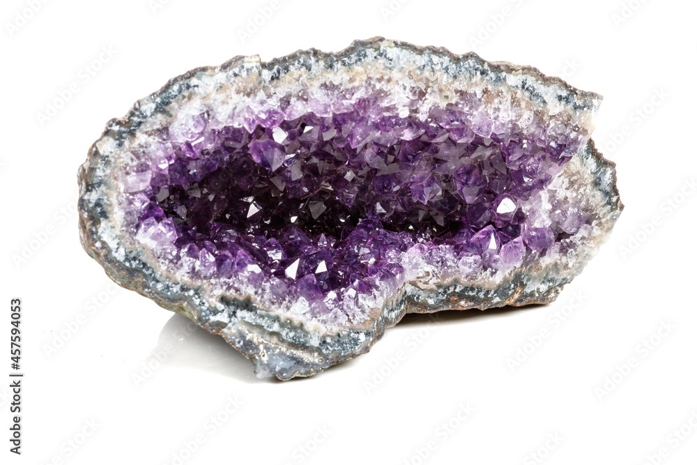 Macro Mineral Stone Amethysts in the rock on a white background