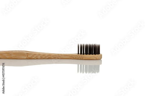 Eco charcoal toothbrush with wooden handle. Caring for nature. Isolated on white background. Space for text.