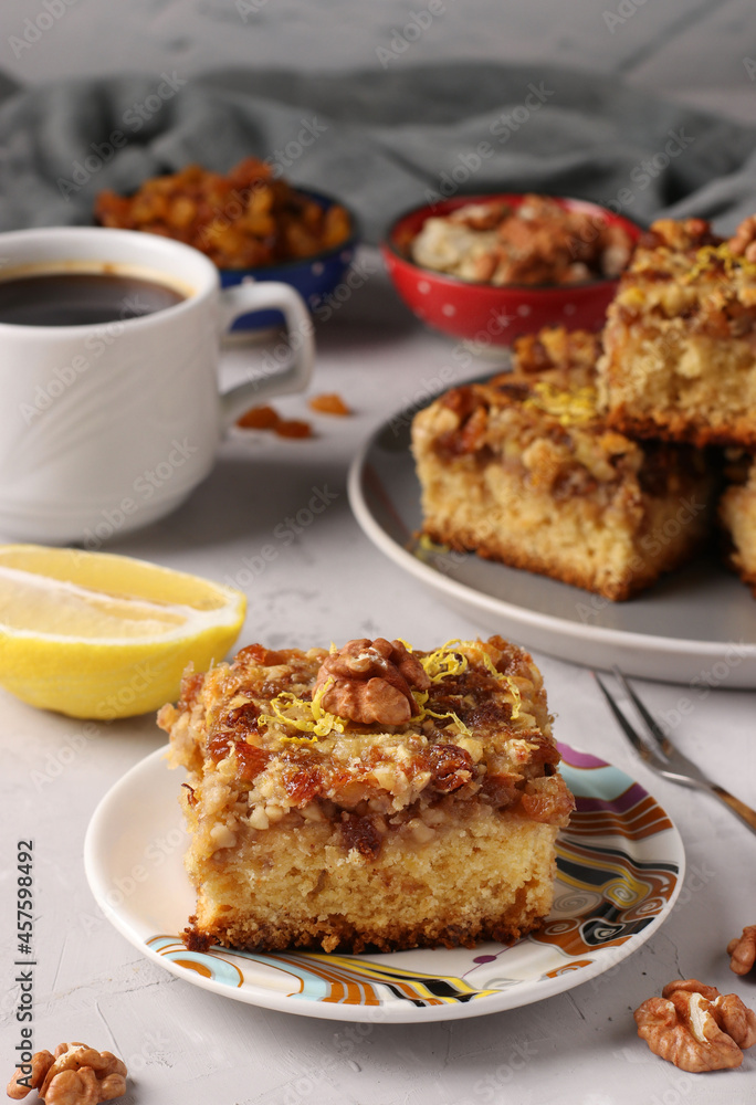 Homemade lemon pie with raisins and nuts on gray table, vertical format