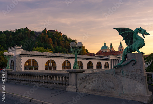 Dragon bridge in Ljubljana in sunset with Castle and cathedral background photo