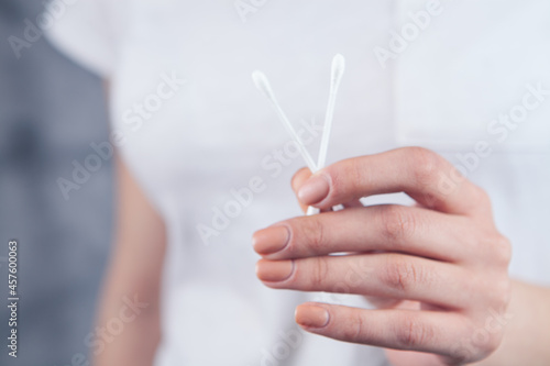 woman holding cotton swabs in her hand