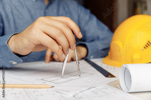 Construction engineer working on blueprint architectural project at desk in office