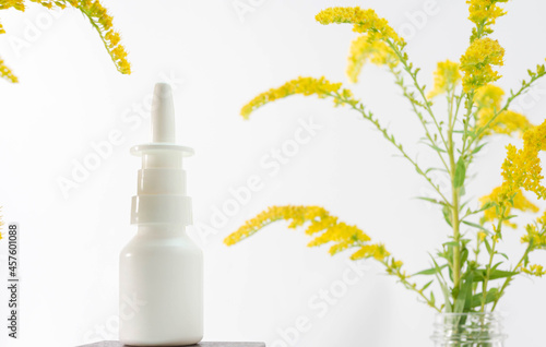 Nasal spray from natural yellow herbs on a white background copy space, homeopathy, medicinal forest plants with a jar of medicines. Natural remedy for the nose. photo