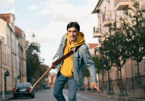 Happy guy with a guitar on the street