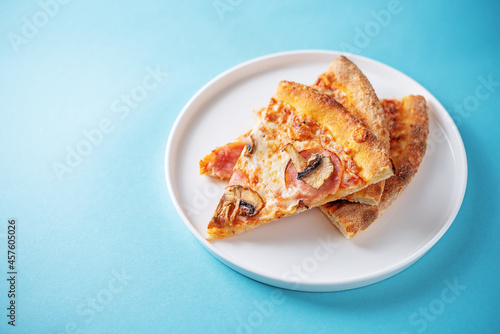 Fresh baked pizza with ham and mushrooms on a background