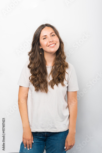 Vertical portrait of a young smiling at the camera woman over white background.