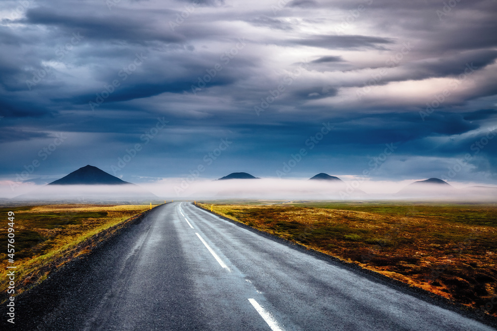 A typical Icelandic landscape and an empty road leads into the distance. Iceland, Europe.