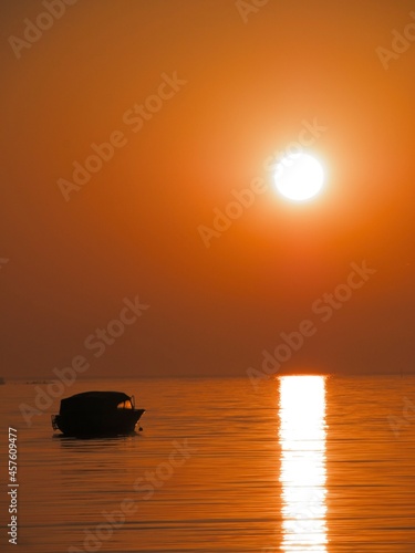 Small boat in red sunrise. © Nicklas