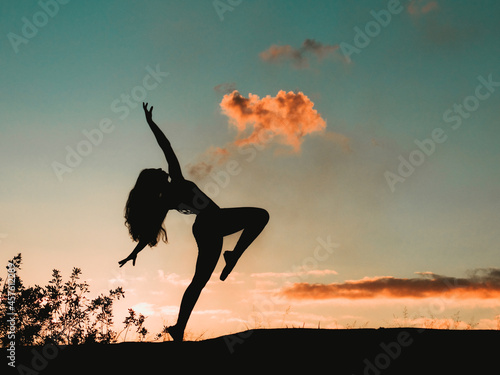Mulher bailarina fazendo poses em um parque ao Nascer do sol