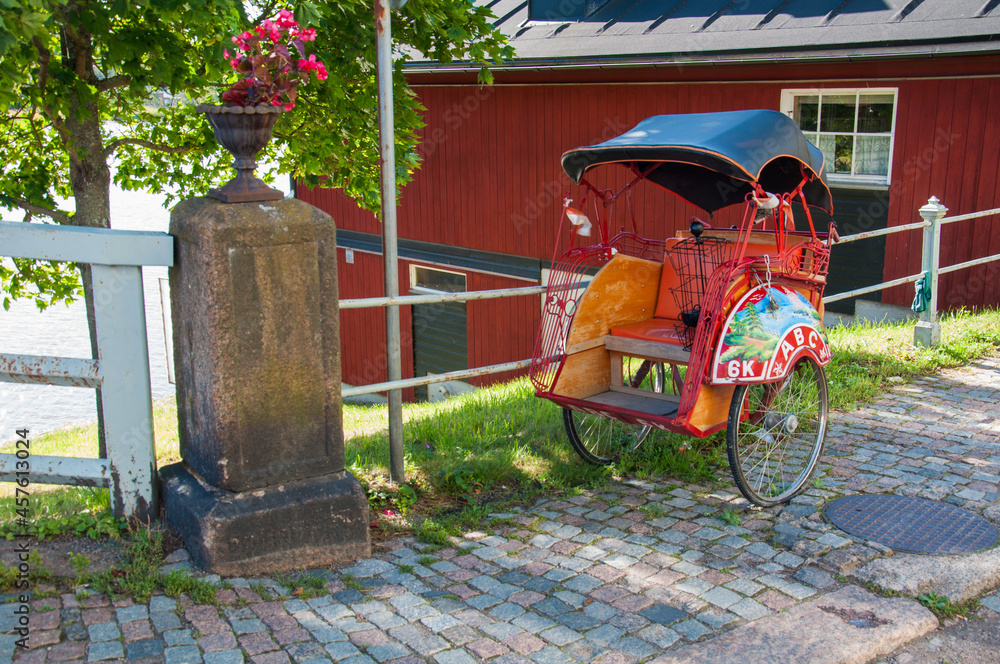 Red rickshaw on a background of red wooden building
