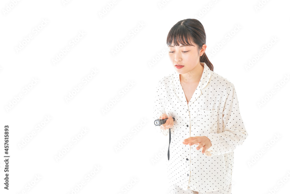 懐中電灯を使う若い女性 懐中電灯を使う若い女性