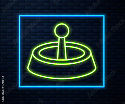 Glowing neon line Casino roulette wheel icon isolated on brick wall background. Vector