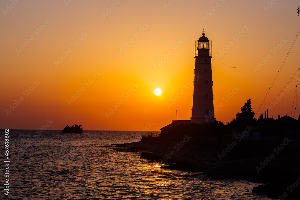 Lighthouse on the sea coast at sunset