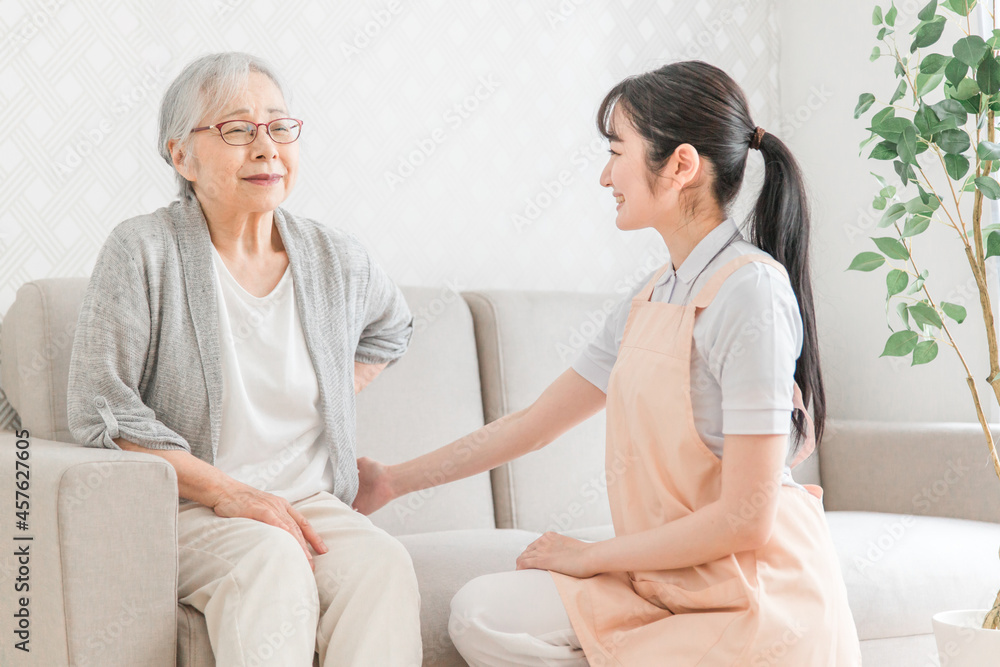 Fototapeta premium 訪問介護・腰をおさえる高齢者女性(腰痛)