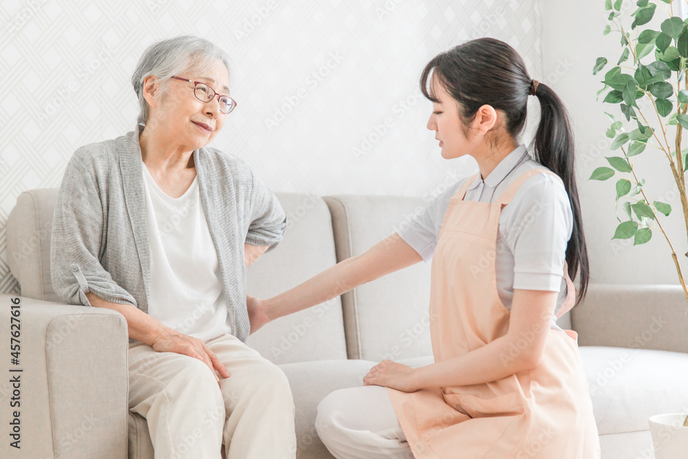 Obraz premium 訪問介護・腰をおさえる高齢者女性(腰痛)