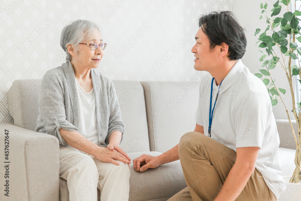 Obraz premium 訪問介護する男性と高齢者(笑顔)