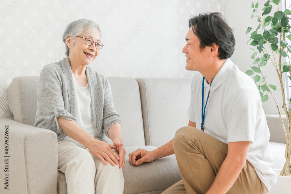 訪問介護する男性と高齢者(笑顔)
訪問介護する男性と高齢者(笑顔)