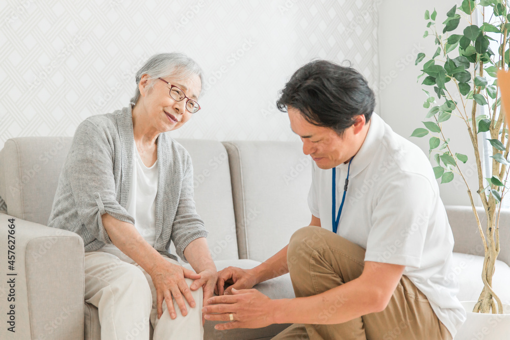 訪問介護する男性と高齢者(膝)
訪問介護する男性と高齢者(膝)