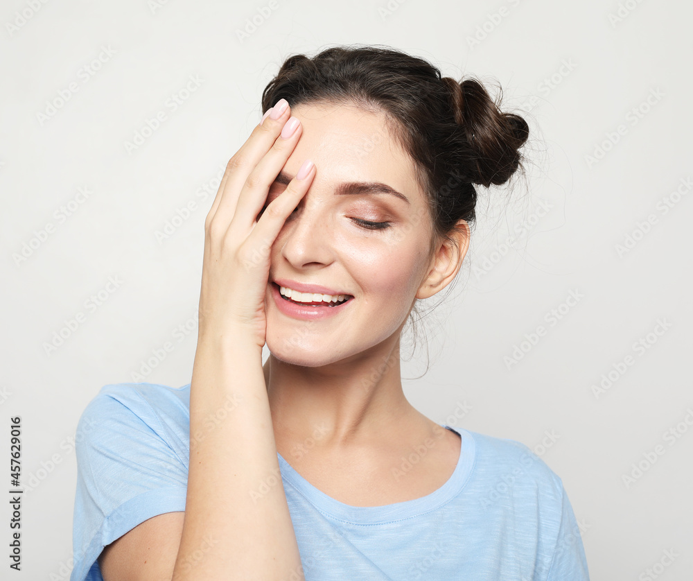 Young woman with her hands covering her eyes. Young woman with her hands covering her eyes.
