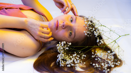 portrait of a girl with white small flowers on a white background. acne