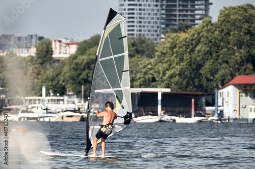 Windsurfer surfing on a windy day at the city river.