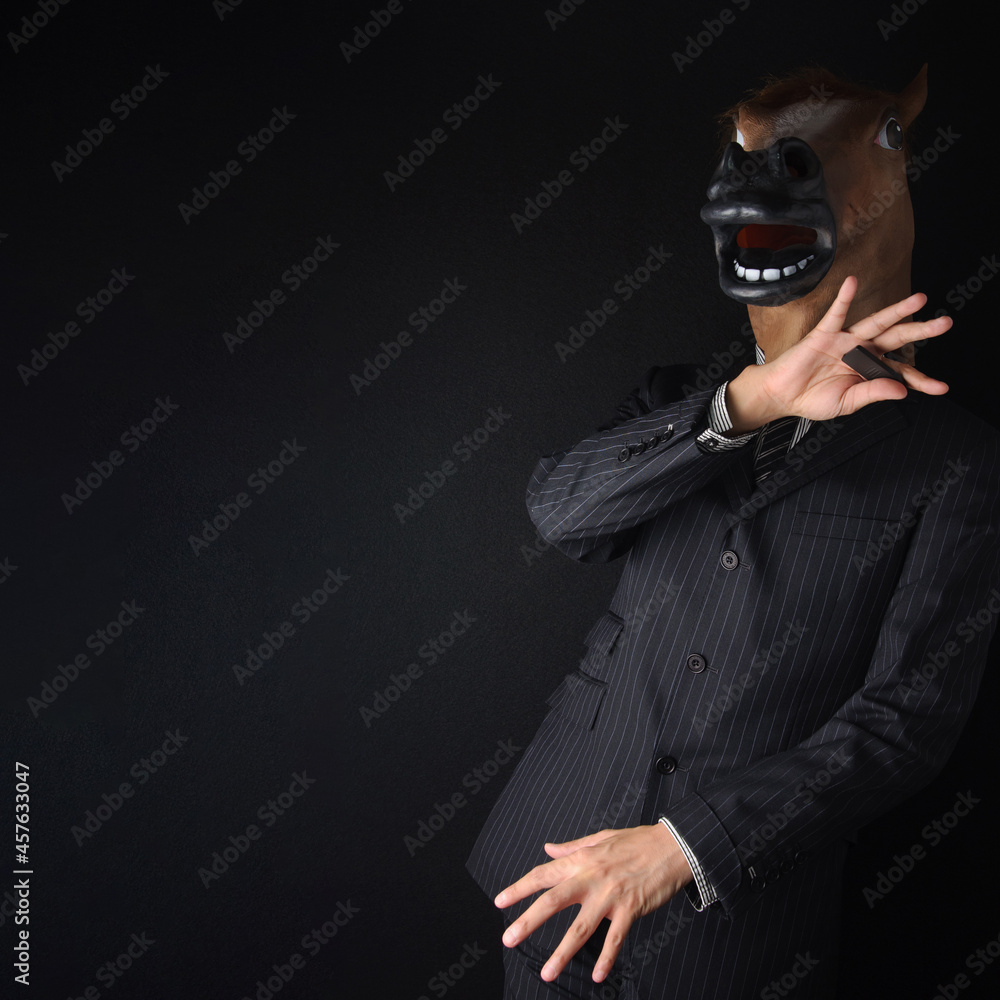 馬のマスクを被ったスーツのビジネスマン ジョジョ立ちのようなポーズ 黒背景 Stock Foto Adobe Stock