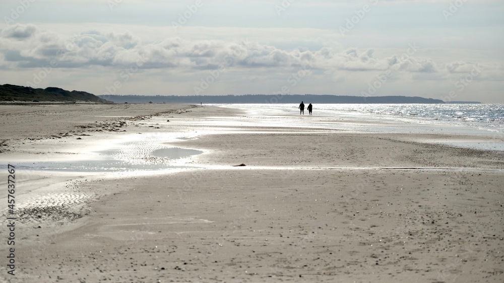Menschen spazieren am Nordseestrand bei Ebbe