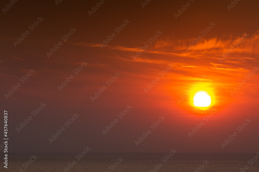 Bright warm sun on sky background. Dawn or sunset.