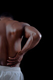 Healthy young african man exercising Pain back. Bodybuilder training on a black background.