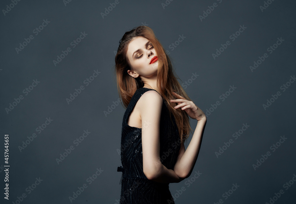 Fototapeta premium cheerful woman in a black dress fashion Lifestyle dark background