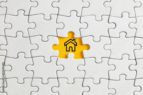 House icon on missing puzzle piece. To find a house for rent or sale concept. © Cagkan