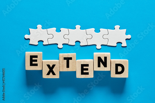 To extend a business contract or time extension. The word extend on wooden cubes.