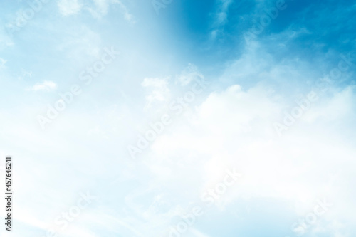 Abstract nature background scattering of white clouds in the bright blue sky.