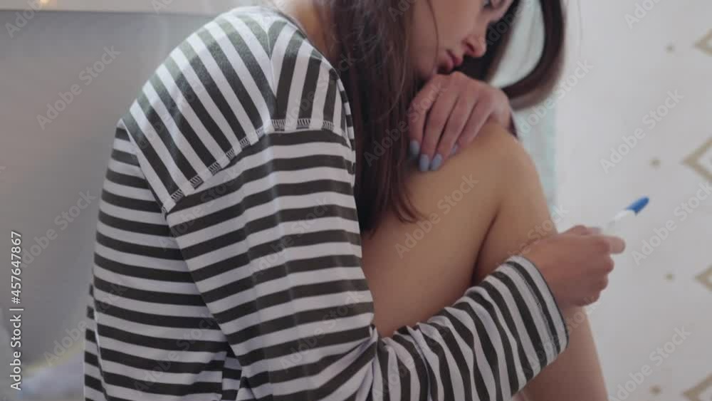 sad girl sitting on the bathroom floor with a pregnancy test. the concept of a positive or negative pregnancy test or other problems related to the position and health of women sad girl sitting on the bathroom floor with a pregnancy test. the concept of a positive or negative pregnancy test or other problems related to the position and health of women