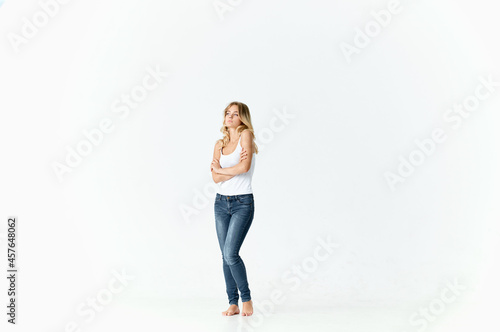 pretty woman in jeans posing fashion barefoot light background