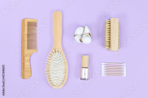 Group of eco friendly wooden beauty and hygiene products like comb and soap on violet background