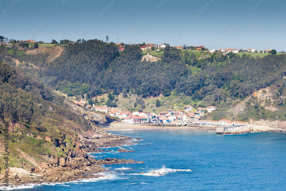 general view, with the sea in the foreground of the rural and fishing village and the bay of tazones in asturias, spain. most beautiful village in spain, sunny day.