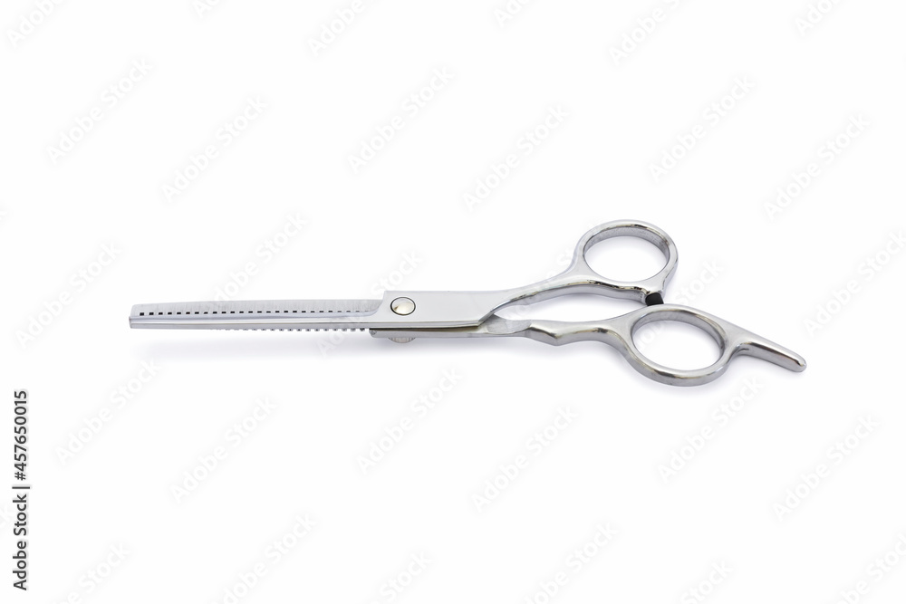 A opened silver hair cutting scissors for hair filibustering with isolated on white background. A opened silver hair cutting scissors for hair filibustering with isolated on white background.