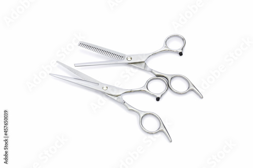 Two pairs of silver hairdressing scissors for hair cutting with isolated on white background.