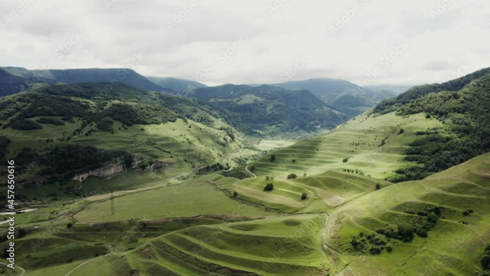 A gentle mountain slope with grass with waves of terraces from a quadcopter A gentle mountain slope with grass with waves of terraces from a quadcopter