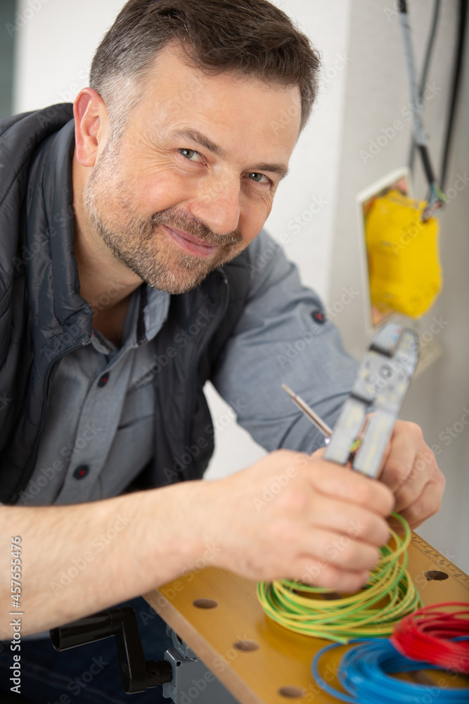 male electrician with a cheeky grin using cable cutters male electrician with a cheeky grin using cable cutters