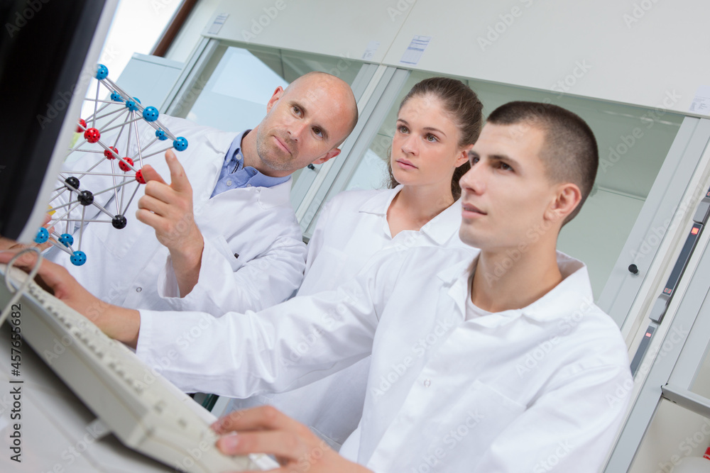 Fototapeta premium students and teacher looking at teacher by model molecules