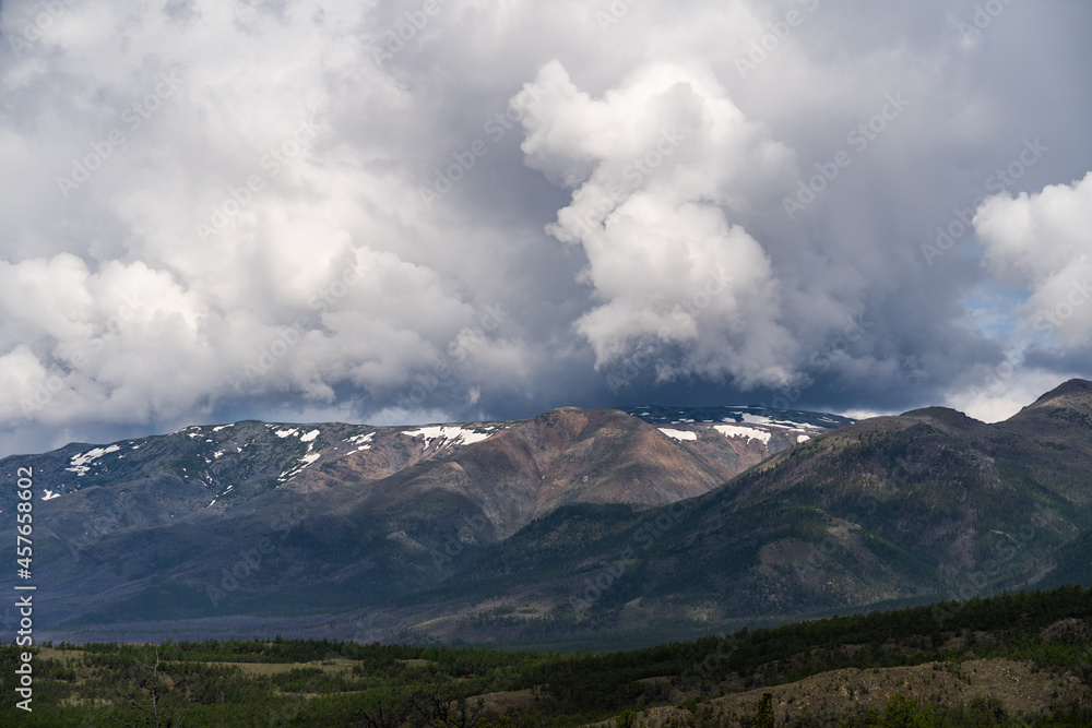 Fototapeta premium Inspirational mountain views. Thick gray clouds over the peaks. Travel and tourism concept.