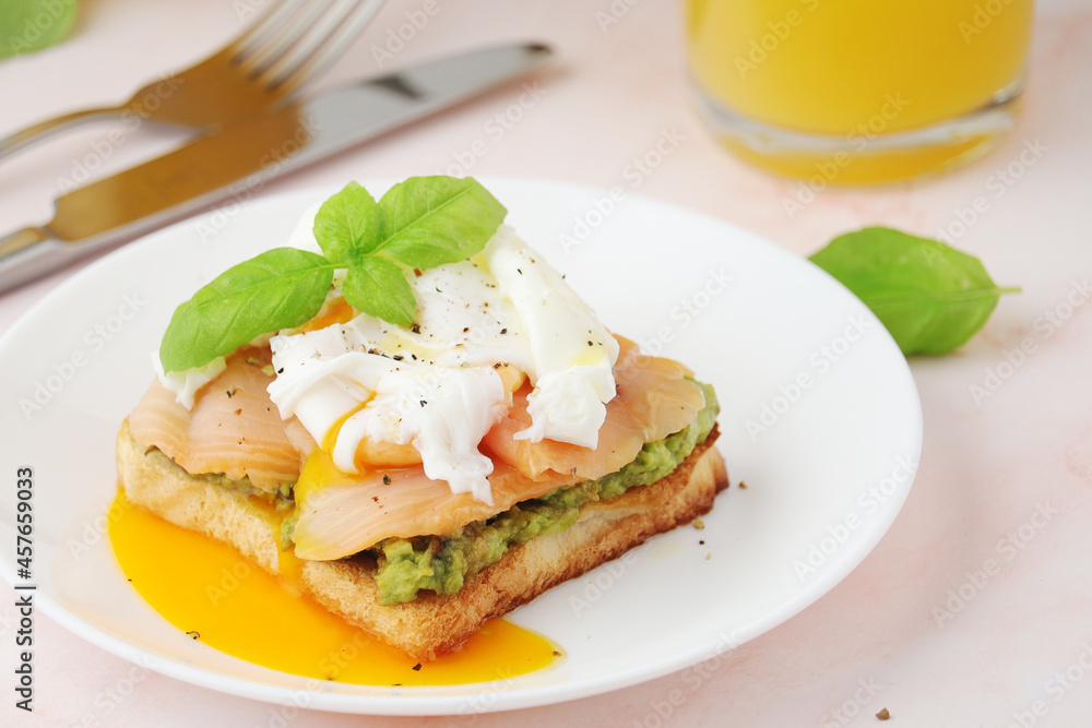 Breakfast with a sandwich with poached egg and avocado