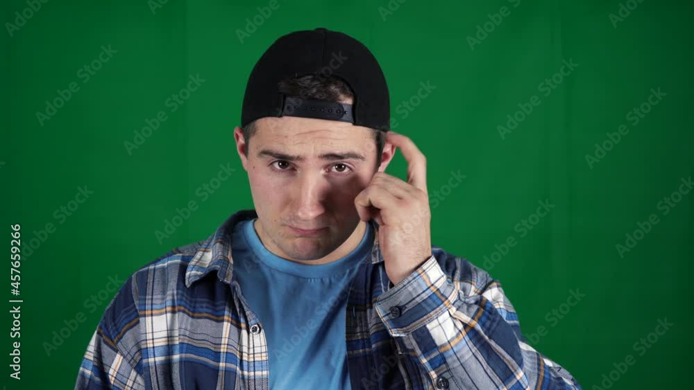 man twists his finger near his head on a green screen. green background chromakey man twists his finger near his head on a green screen. green background chromakey