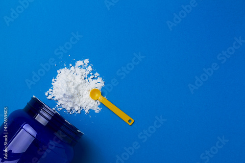 sports supplement creatine powder on blue background copy space photo