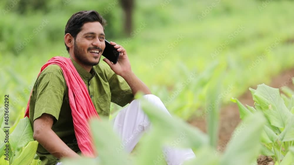 Indian farmer talking on smartphone at agriculture field. Indian farmer talking on smartphone at agriculture field.