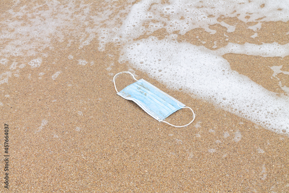 Used protective face mask in sea and plastic pollution concept Used protective face mask in sea and plastic pollution concept